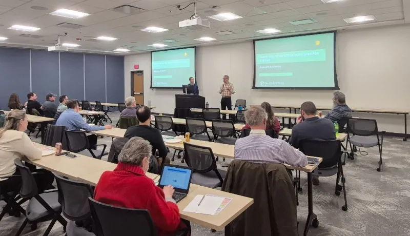 Two people present to a room about electrification opportunities.