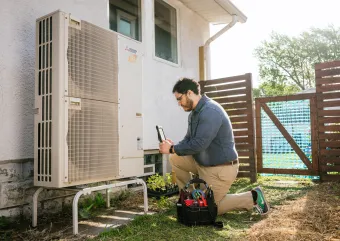 A person inspects a heat pump.