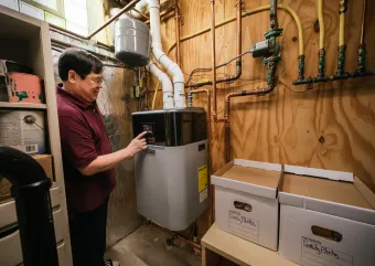 person checking boiler in basement