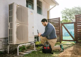 A person inspects a heat pump.
