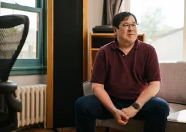 Lester sits in his home, which is heated and cooled with a cold climate air source heat pump.