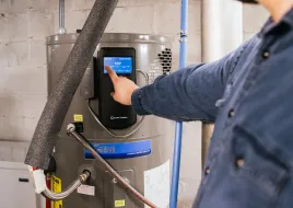 A person adjusts a heat pump water heater.