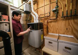 person checking boiler in basement