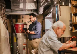 two people in basement working on the boiler